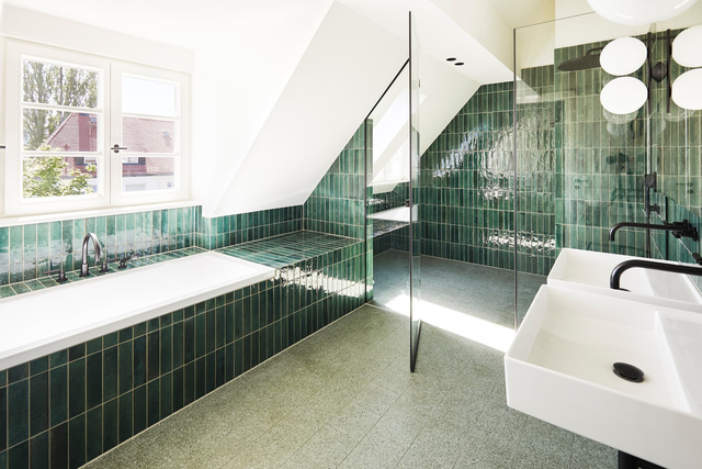 Hauptbad unter der Dachschräge mit Badewanne, Glasdusche und grünen Fliesen – Stadthaus Fafnerstraße, München · Nymphenburg